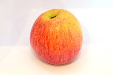 Beyaz arka planda tonda bir sarı ve kırmızı elma