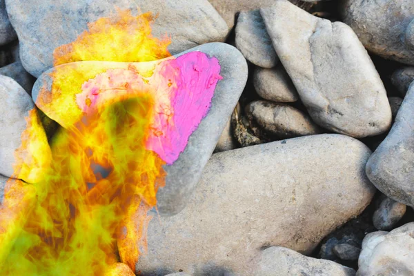 Cutting fire diving pink heart painted with lipstick on piece of stone. Symbol of the end of love and of two people break up and divorce