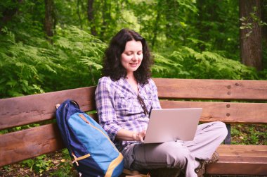 Parkta dizüstü bilgisayar kullanan kadın seyahat. Serbest kavramı iş doğa üzerinde çalışma seyahat