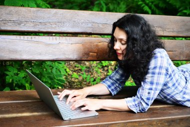 Parkta dizüstü bilgisayar kullanan kadın seyahat. Serbest kavramı iş doğa üzerinde çalışma seyahat