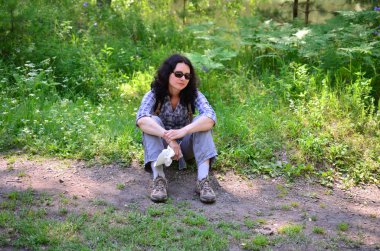 Kadın turist ile orman toprağa oturup sırt çantası