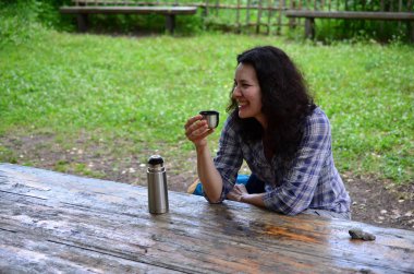 Kadın seyahat Termos şişe kapağı açık havada içki içer. Kız zammı sonra aittir.