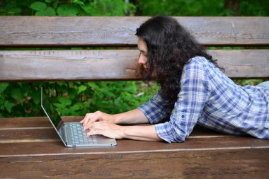 Parkta dizüstü bilgisayar kullanan kadın seyahat. Serbest kavramı iş doğa üzerinde çalışma seyahat
