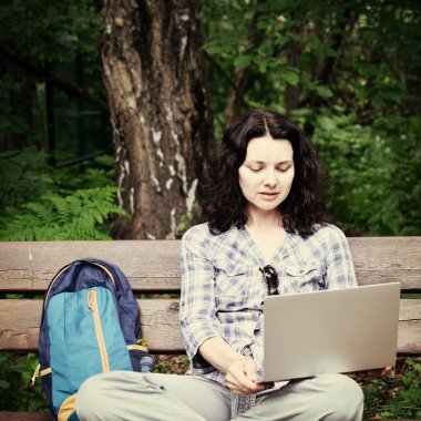 Parkta dizüstü bilgisayar kullanan kadın seyahat. Serbest kavramı iş doğa üzerinde çalışma seyahat