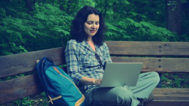 Parkta dizüstü bilgisayar kullanan kadın seyahat. Serbest kavramı iş doğa üzerinde çalışma seyahat