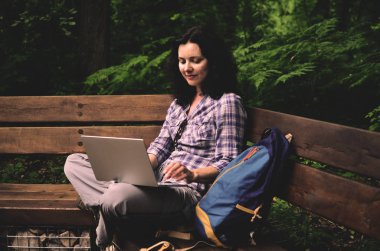 Parkta dizüstü bilgisayar kullanan kadın seyahat. Serbest kavramı iş doğa üzerinde çalışma seyahat