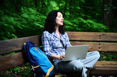Parkta dizüstü bilgisayar kullanan kadın seyahat. Serbest kavramı iş doğa üzerinde çalışma seyahat