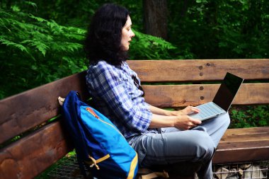 Parkta dizüstü bilgisayar kullanan kadın seyahat. Serbest kavramı iş doğa üzerinde çalışma seyahat