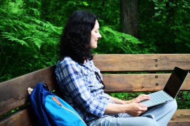 Parkta dizüstü bilgisayar kullanan kadın seyahat. Serbest kavramı iş doğa üzerinde çalışma seyahat