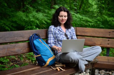 Parkta dizüstü bilgisayar kullanan kadın seyahat. Serbest kavramı iş doğa üzerinde çalışma seyahat
