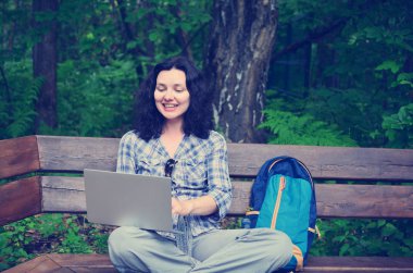 Parkta dizüstü bilgisayar kullanan kadın seyahat. Serbest kavramı iş doğa üzerinde çalışma seyahat