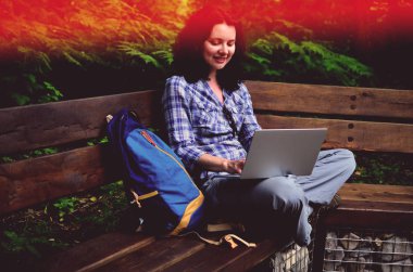 Parkta dizüstü bilgisayar kullanan kadın seyahat. Serbest kavramı iş doğa üzerinde çalışma seyahat