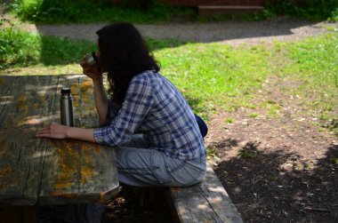 Kadın seyahat Termos şişe kapağı açık havada içki içer. Kız zammı sonra aittir.