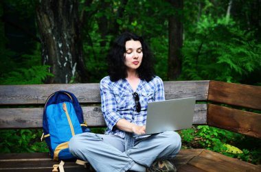 Parkta dizüstü bilgisayar kullanan kadın seyahat. Serbest kavramı iş doğa üzerinde çalışma seyahat