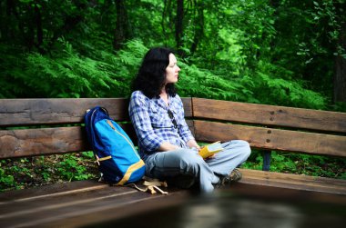 Kitap okuma ve Park'ta rahatlatıcı kadın seyahat. Serbest çalışma ve tatil sırasında çalışma