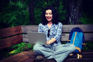 Parkta dizüstü bilgisayar kullanan kadın seyahat. Serbest kavramı iş doğa üzerinde çalışma seyahat