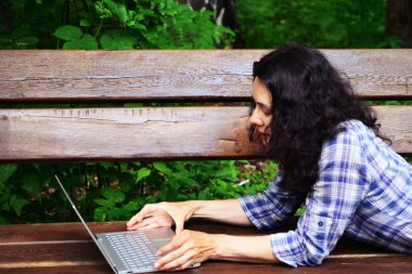 Parkta dizüstü bilgisayar kullanan kadın seyahat. Serbest kavramı iş doğa üzerinde çalışma seyahat