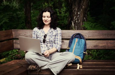 Parkta dizüstü bilgisayar kullanan kadın seyahat. Serbest kavramı iş doğa üzerinde çalışma seyahat