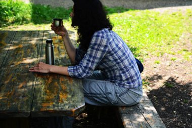 Kadın seyahat Termos şişe kapağı açık havada içki içer. Kız zammı sonra aittir.