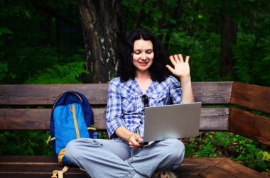 Parkta dizüstü bilgisayar kullanan kadın seyahat. Serbest kavramı iş doğa üzerinde çalışma seyahat