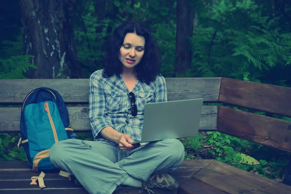 Parkta dizüstü bilgisayar kullanan kadın seyahat. Serbest kavramı iş doğa üzerinde çalışma seyahat