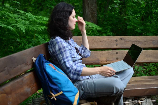 Parkta dizüstü bilgisayar kullanan kadın seyahat. Serbest kavramı iş doğa üzerinde çalışma seyahat
