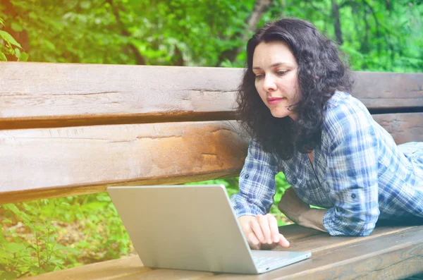 Parkta dizüstü bilgisayar kullanan kadın seyahat. Serbest kavramı iş doğa üzerinde çalışma seyahat