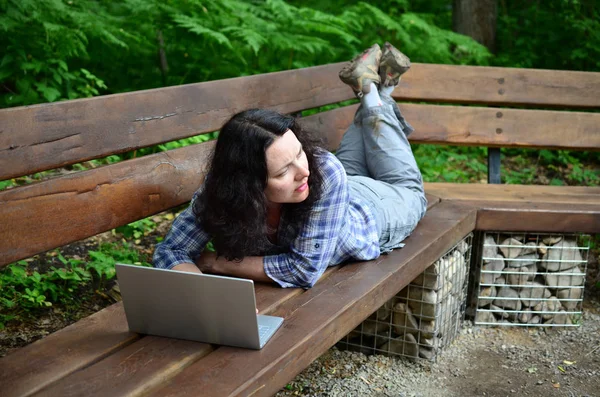 Parkta dizüstü bilgisayar kullanan kadın seyahat. Serbest kavramı iş doğa üzerinde çalışma seyahat