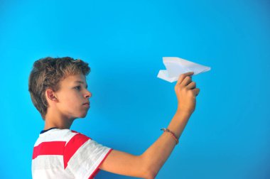 Çocuk ile mavi arka plan üzerinde bir kağıt uçak