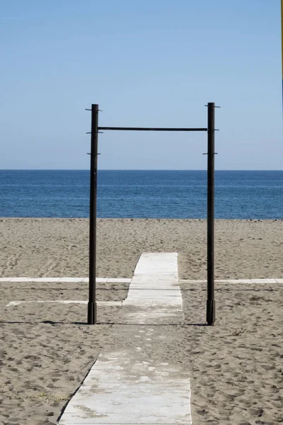 铁框围绕着海滩上的木制方式 它看起来就像一个通往大海的入口 — 图库照片