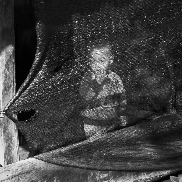 Mae Salong 清莱府 2017年1月22日 黑白图片与一个小男孩吮吸他的手指背后撕裂的帆布与透明Weft — 图库照片