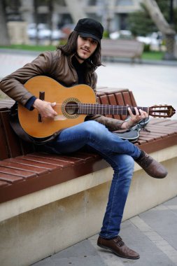 14-11-2018.Baku.Azerbaijan.Musician playing the guitar on the street in the photo close-up clipart