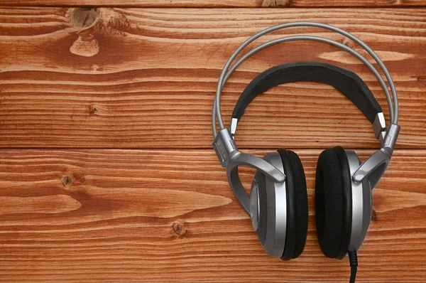 Vintage koptelefoon voor het luisteren naar geluid en muziek op een houten — Stockfoto