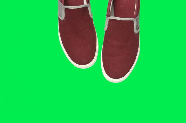 Yeşil arka planda gündelik kahverengi spor ayakkabılar. — Stok fotoğraf
