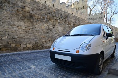 Bakü caddesinde beyaz subcompact araba