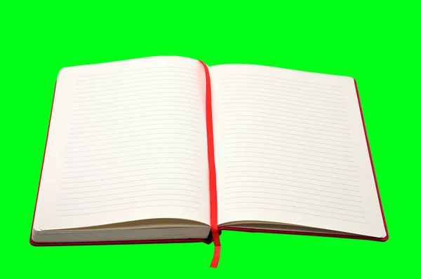Červený zápisník na zeleném pozadí — Stock fotografie
