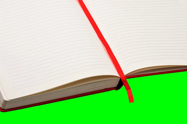 Czerwony notatnik na zielonym tle — Zdjęcie stockowe