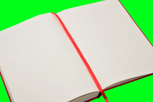 绿色背景的红色笔记本 — 图库照片
