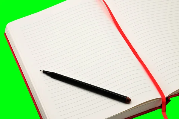 绿色背景的红色笔记本 — 图库照片