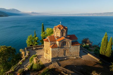Kaneo Hill 'deki kilisenin duvarlarında günün ilk ışığı. Arka planda göl manzarası var. Tatil ve Ohri temalı çalışmalar için uygun.