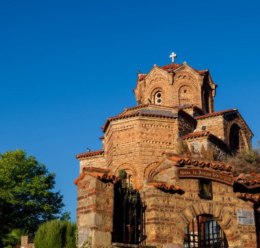 St. John Kilisesi 'nin ve Kaneo Hill' deki kapısının yakın çekimi. Kilise turuncu taş duvarları ve mavi gökyüzü ile göze çarpıyor..