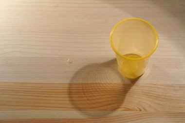Ahşap zemin üzerinde su olan tek kullanımlık plastik bardaklar.