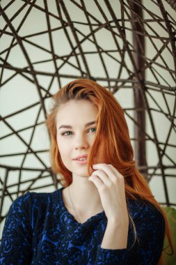 Güzel genç kadın odada bir kolye sandalyede oturur