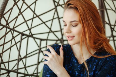 Güzel genç kadın odada bir kolye sandalyede oturur