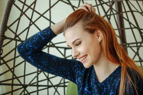 Güzel genç kadın odada bir kolye sandalyede oturur