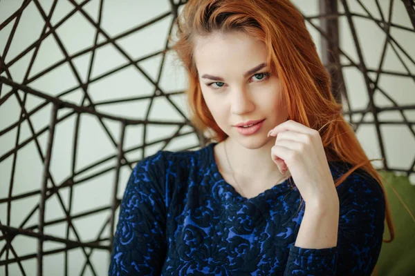 Güzel genç kadın odada bir kolye sandalyede oturur