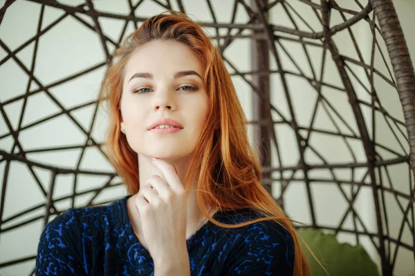 Güzel genç kadın odada bir kolye sandalyede oturur