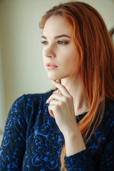 Portret pięknej młodej kobiety z rude włosy w pobliżu okna — Zdjęcie stockowe