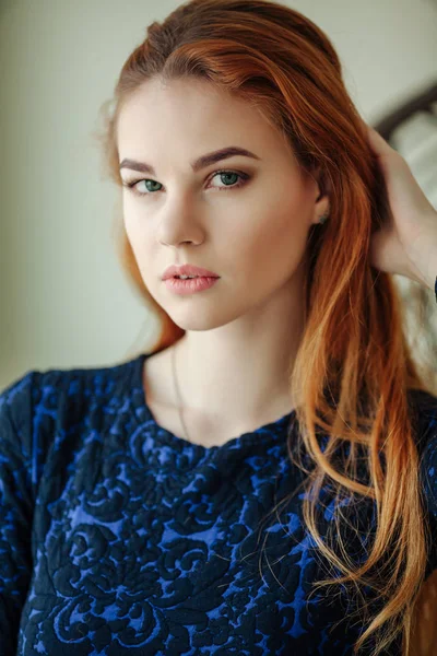 Porträt einer schönen jungen Frau mit roten Haaren am Fenster — Stockfoto