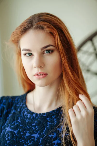 Egy gyönyörű fiatal nő az ablak mellett piros hajjal portréja — Stock Fotó